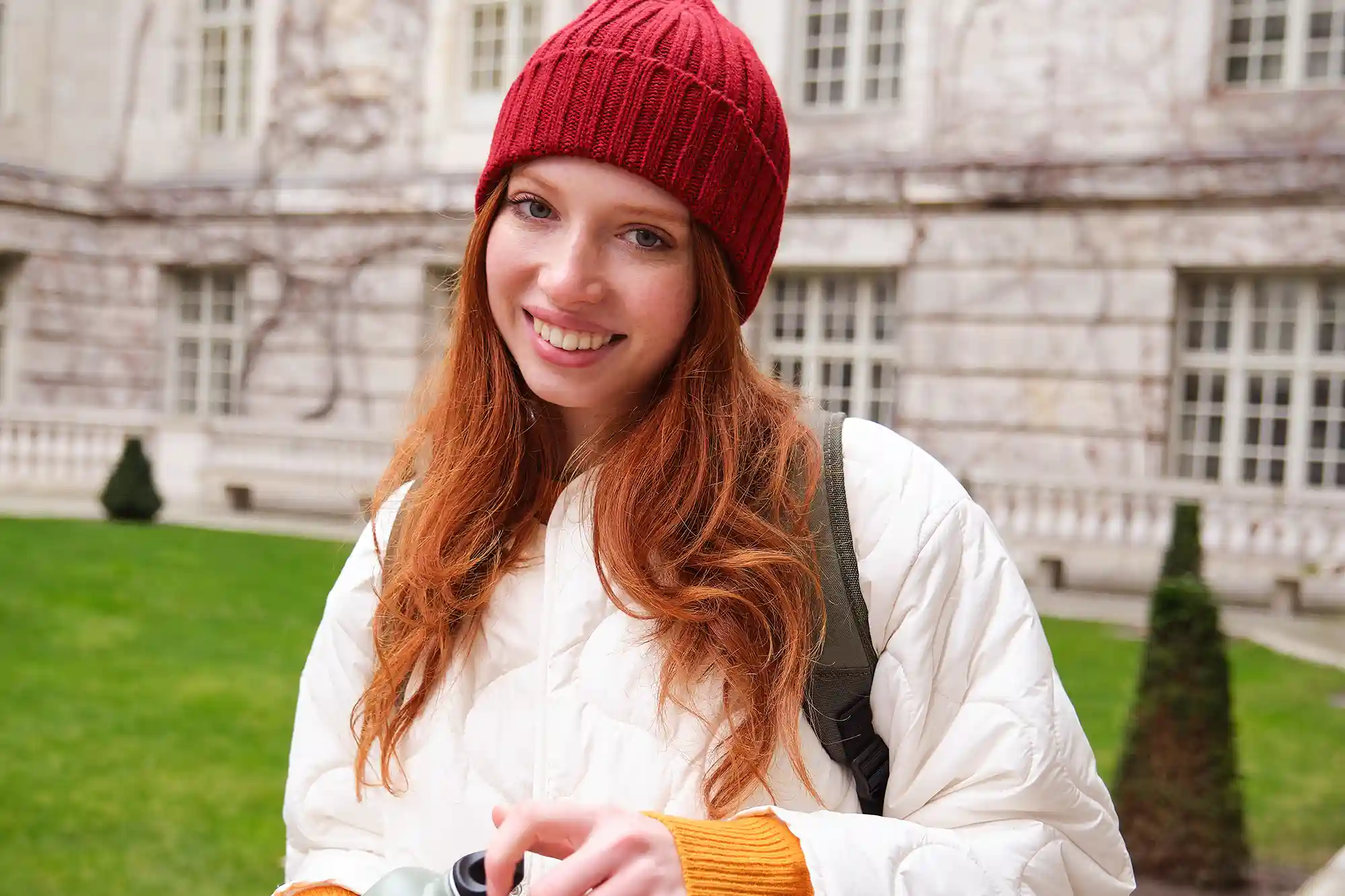 portrait-happy-girl-traveler-drinking-hot-tea-from-thermos-while-walking-exploring-city.webp